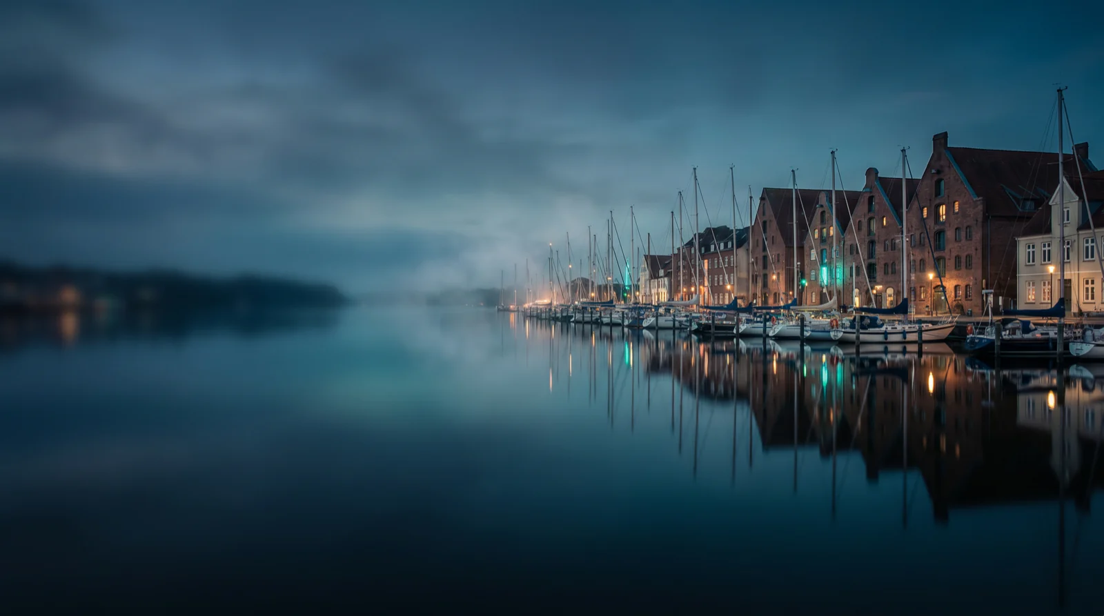 Flensburger Hafen zur blauen Stunde – historische Hafenhäuser und Segelboote am Wasser